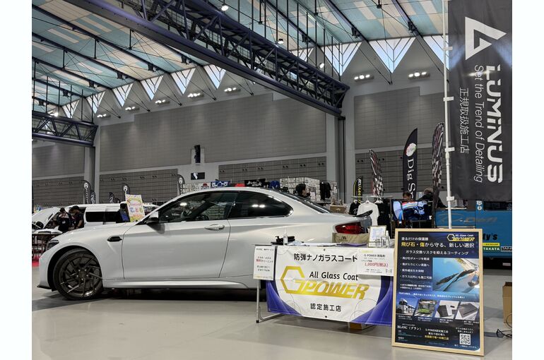   東北オートリミックス2026のBLANC出展ブース。LUMINUSののぼりとG-POWERの展示テーブル、BMW M2コンペティションを展示した会場の様子    