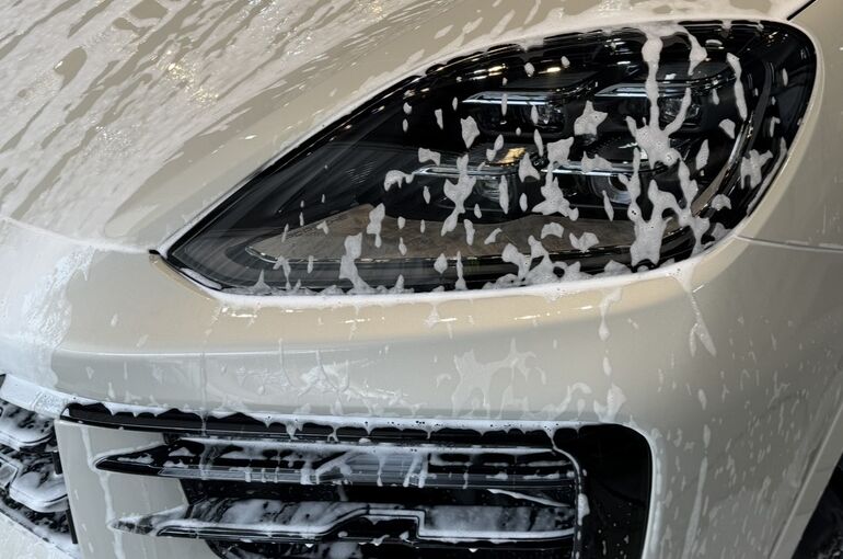   研磨後に洗車を行う新車ポルシェ カイエン E-Hybridのフロント    